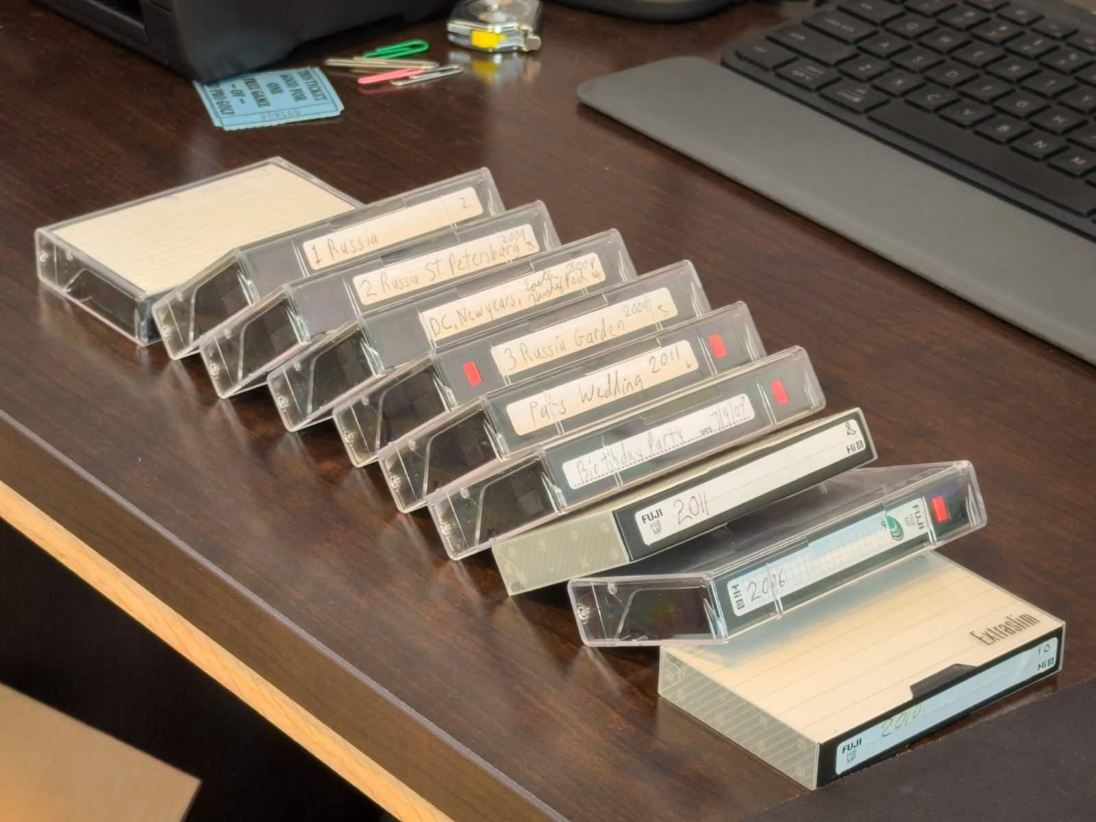 A row of labeled Hi8 and video cassettes staged for transfer